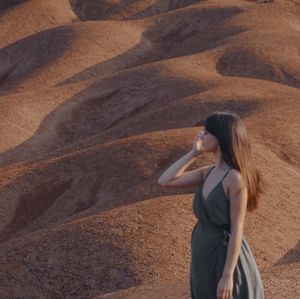 Rear view of woman standing on sand