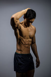 Portrait of young man standing against white background