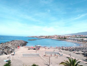 Panoramic view of people on beach against blue sky