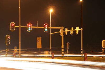 Stoplights over light trails at night