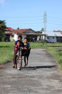 Man riding bicycle on road against sky