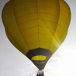 Low angle view of hot air balloons flying against sky