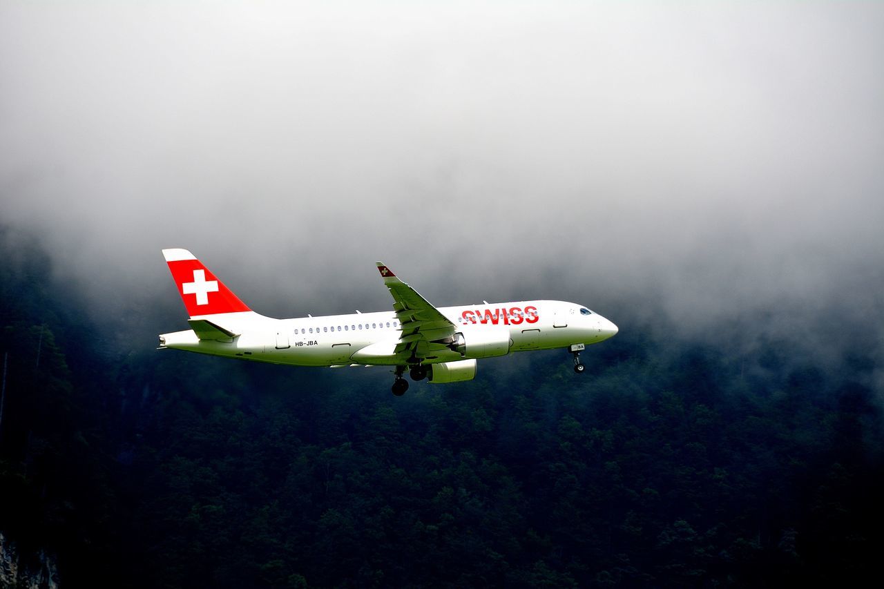 AIRPLANE FLYING ABOVE SIGN