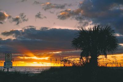 Scenic view of sea against cloudy sky at sunset