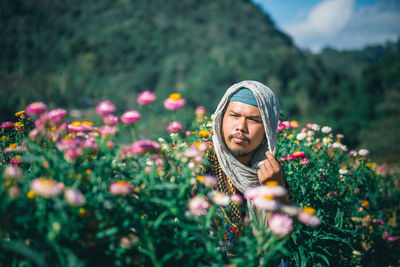 Man looking away by flowering plants