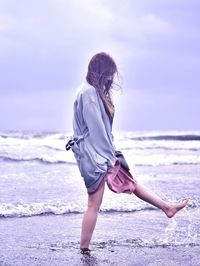 Side view of woman standing at beach