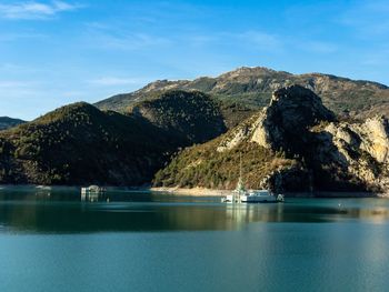 Scenic view of lake by mountains against sky