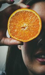 Close-up of hand holding orange