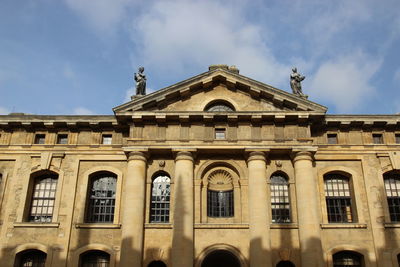 Low angle view of building against cloudy sky