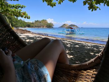 Low section of man lying on beach