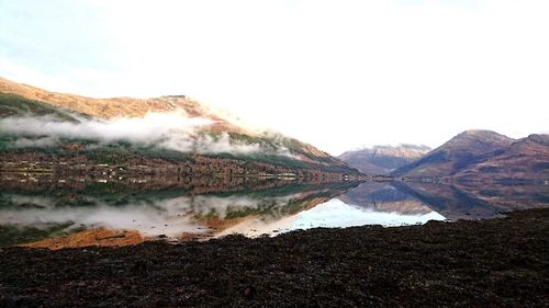 Scenic view of lake and mountains against sky