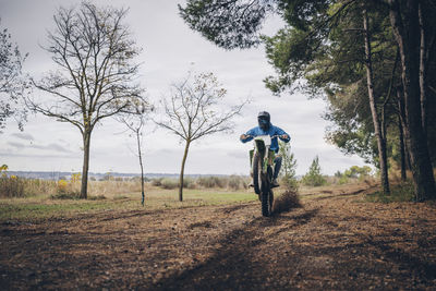 Rear view of man riding motorcycle on road