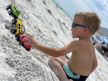 Rear view of a boy sitting on the beach