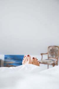 Low section of woman on bed at home