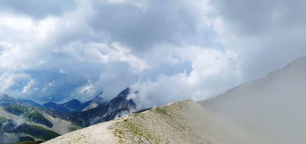 Panoramic view of mountains against cloudy sky