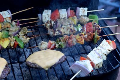 High angle view of skewers and meat on barbeque grill