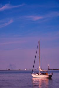 Sailboat sailing on sea against sky during sunset