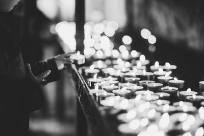 Person hand by illuminated candles