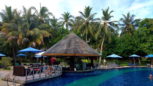 Gazebo by swimming pool against sky