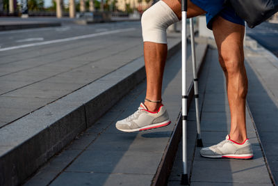 Low section of man walking on sidewalk