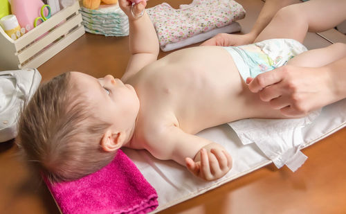 High angle view of baby lying on bed