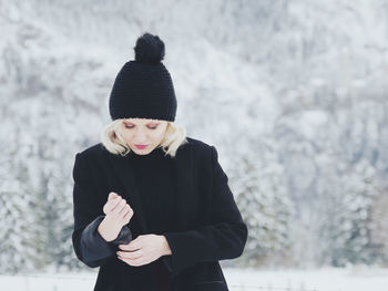 Mid adult woman standing on snow covered mountain