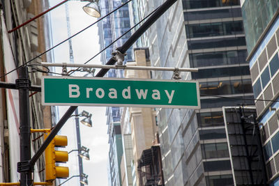 Low angle view of road signs against buildings in city