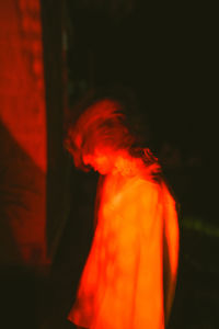 Woman standing by red light
