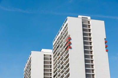 The six red balconies on the apartment building on a sunny day