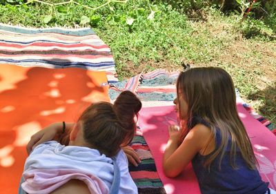 Two girls lying on yoga mats outdoors