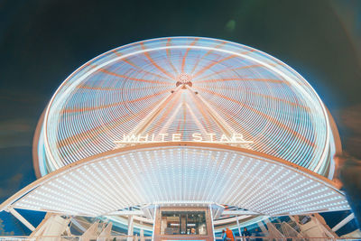 Low angle view of illuminated ferris wheel against sky