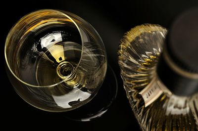 High angle view of cognac in snifter and bottle on table