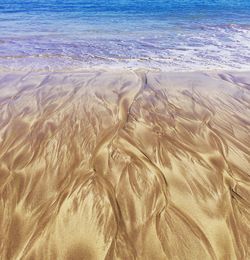 Sand dunes at beach against sky