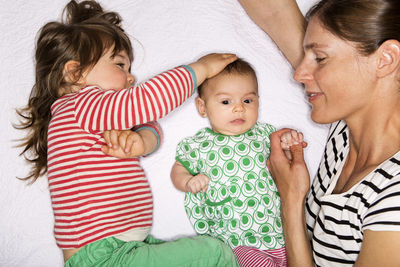 High angle view of family lying on bed