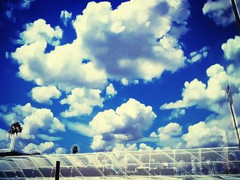 Low angle view of fence against blue sky