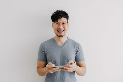 Portrait of smiling man standing against white background