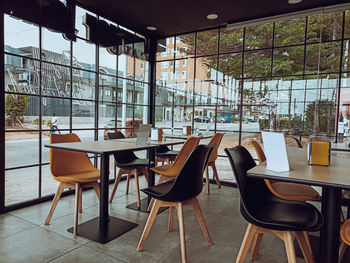 Inside a glassed-in restaurant, with tables and chairs