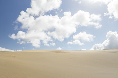 Scenic view of sand dunes against sky