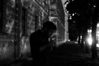 Man smoking cigarette while standing in city