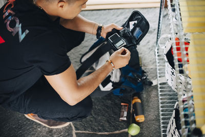 High angle view of man preparing diabetes kit while crouching at home