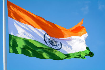 Low angle view of flag against blue sky