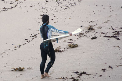 Full length of boy running on sand at beach