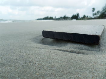 Surface level of sandy beach against sky