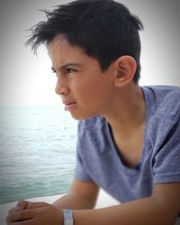Portrait of young man looking away at sea