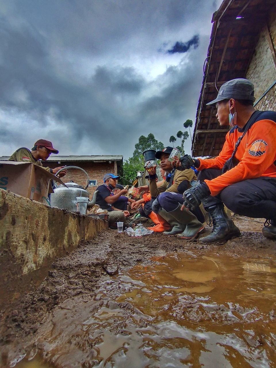 GROUP OF PEOPLE WORKING AT SHORE AGAINST SKY