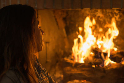 Latin woman in front of the fireplace, in a moment of relaxation and peace.
