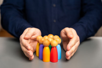 Midsection of man holding tomatoes on table