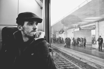 Man looking through window of train