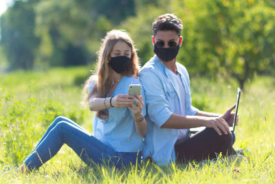 Young couple sitting on field