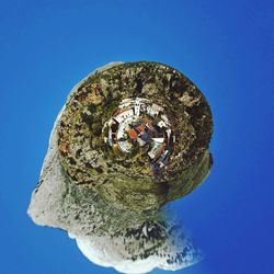 Low angle view of people against clear blue sky